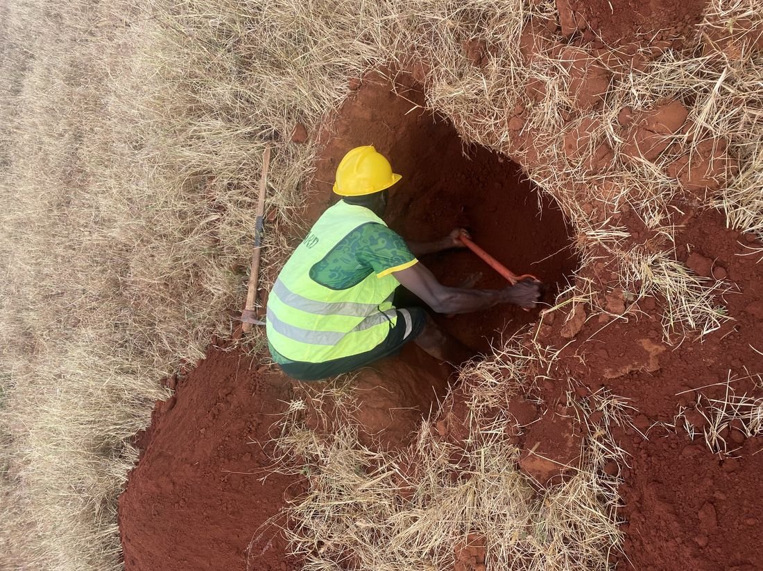 Field crew excavating a trial pit during geotechnical investigation